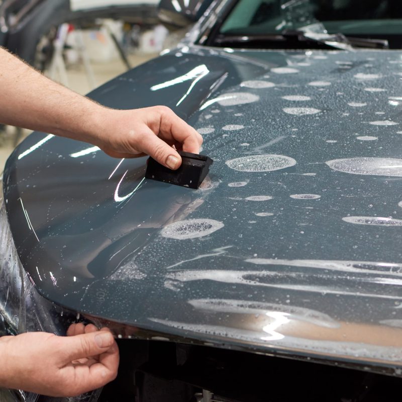 Installation of a protective paint and varnish transparent film on the car. PPF polyurethane film to protect the car paint from stones and scratches. Installation of a protective paint and varnish transparent film on the car. PPF polyurethane film to protect the car paint from stones, marks and scratches.